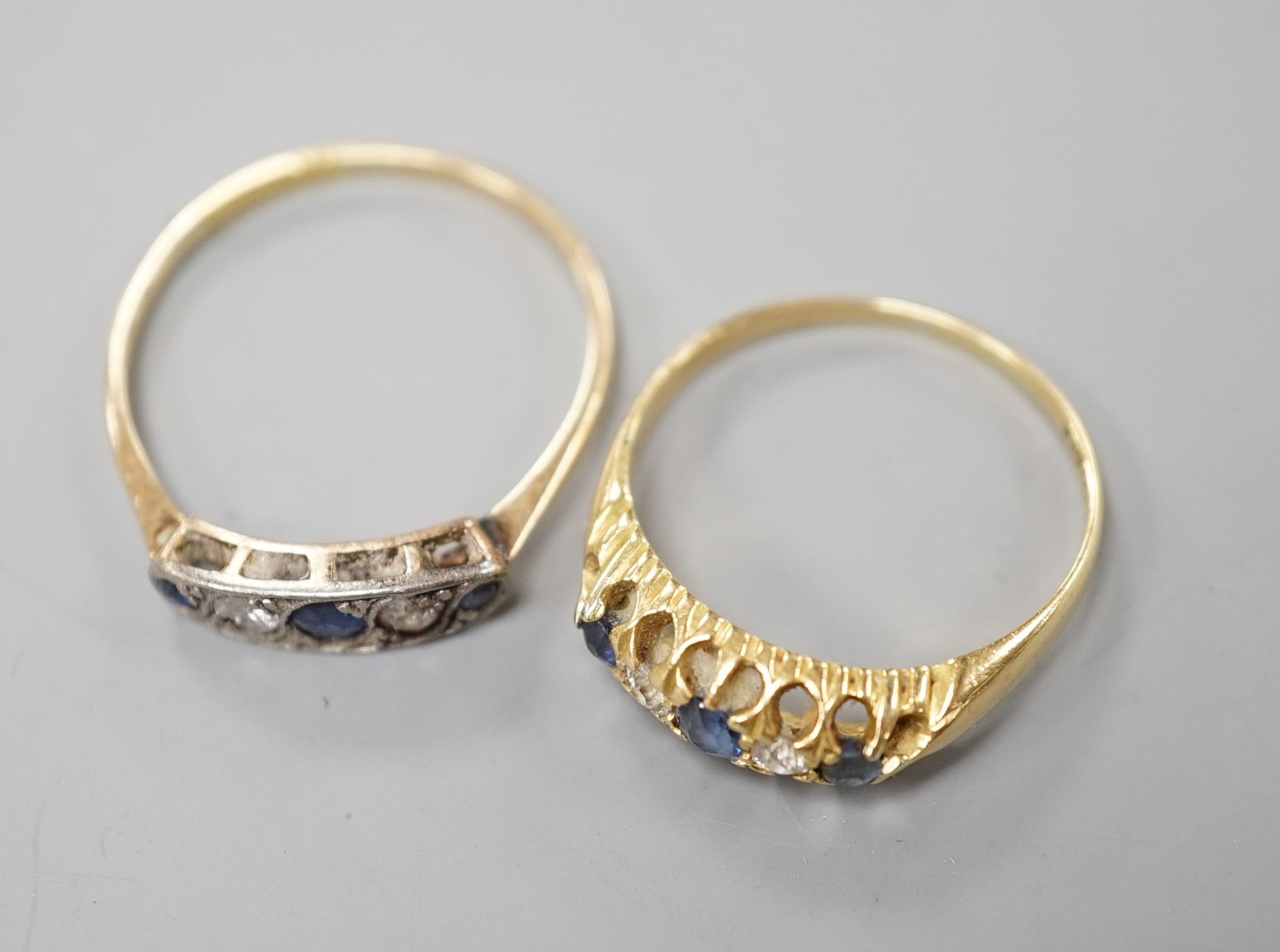 Two early 20th century yellow metal, sapphire and diamond set half hoop rings, sizes P & T, gross weight 5 grams.
